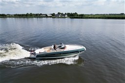 2023 Invictus GT 280 cruising on a serene river with lush green banks.