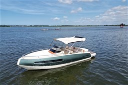 2023 Invictus GT 280 boat on calm water under a clear blue sky.