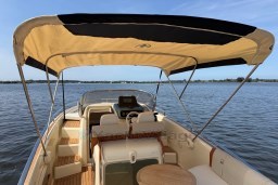 2023 Invictus GT 280 boat with canopy, cruising on a serene lake.