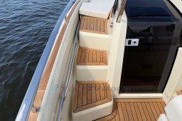 2023 Invictus GT 280 boat with teak steps and sleek design by the water.