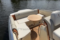 2023 Invictus GT 280 boat interior with elegant seating and wooden table on water.