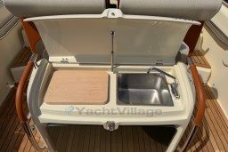 2023 Invictus GT 280 boat kitchenette with sink and cutting board on teak deck.