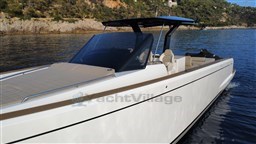 2019 Pardo Yachts 43 cruising on calm waters near rocky shoreline.