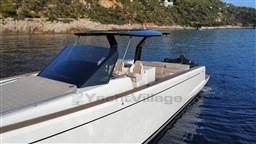 2019 Pardo Yachts 43 cruising on serene waters near a rocky coastline.