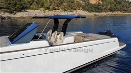 2019 Pardo Yachts 43 cruising on calm waters near a rocky shoreline.