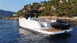 2019 Pardo Yachts 43 cruising near rocky coastline with lush greenery.