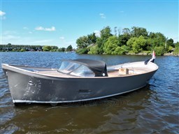1978 Sloop 785 boat on a calm lake with lush green trees.