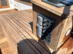 Wooden control panel on a 1978 Sloop 785 sailboat deck, featuring various switches.