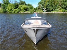 1978 Sloop 785 boat on a calm river with lush green trees.