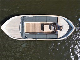 Overhead view of a 1978 Sloop 785 boat on water, featuring wooden deck and seating.