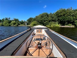 1978 Sloop 785 boat on a serene lake with lush green trees.