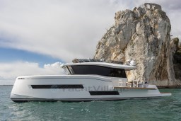 2025 Pardo Yachts Endurance 60 cruising near a rocky cliff.