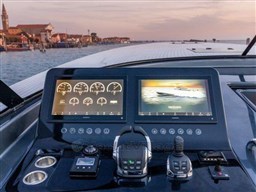 ```json
{
  "alt_text": "2025 VanDutch 56 yacht dashboard with dual screens and controls, scenic waterfront view."
}
```
