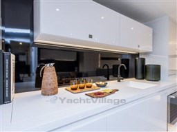 Modern kitchen interior on 2025 VanDutch 56 yacht, featuring sleek white cabinetry and stylish accessories.