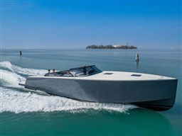 2025 VanDutch 56 yacht cruising on open water with island in background.