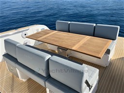 Luxury seating area on 2023 Pardo Yachts 38, featuring elegant wooden table and blue cushions.