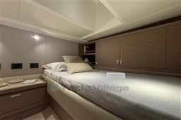 Luxurious cabin interior of 2026 Pardo Yachts 43, featuring elegant bedding and wooden cabinetry.