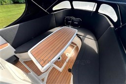 Interior of 2012 Corsiva 690 Tender boat with wooden table and cushioned seating.