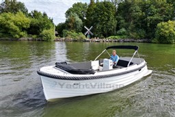 Corsiva 690 Tender boat from 2012 on a scenic lake with lush greenery.