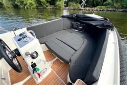 Corsiva 690 Tender 2012 boat interior with cushioned seating and wooden flooring on a calm river.