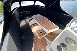 Interior of 2012 Corsiva 690 Tender boat with wooden table and cushioned seating.