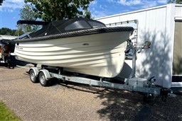 2012 Corsiva 690 Tender boat on trailer, parked outdoors under clear sky.
