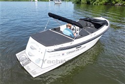 Corsiva 690 Tender boat from 2012 on a calm lake, featuring sleek design and black canopy.