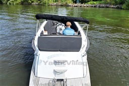 Corsiva 690 Tender 2012 boat on water, person steering, lush greenery in background.