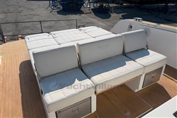Luxury seating on 2022 Pardo Yachts 38, featuring white cushioned upholstery and teak flooring.