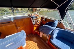 Interior of 2008 INTER 9000 Sportivo boat with blue seating and wooden accents.
