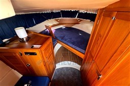 Cozy cabin interior of 2008 INTER 9000 Sportivo with wooden furnishings and blue bedding.