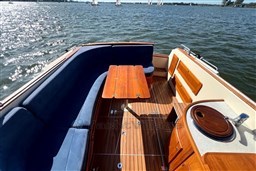 Luxurious 2008 INTER 9000 Sportivo boat interior with wooden deck and blue seating on a sunny day.