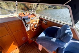 Interior of 2008 INTER 9000 Sportivo boat with wooden dashboard and blue captain's chair.