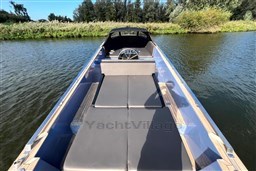 Isloep Rapida 990 boat, 2010 model, cruising on a serene river with lush greenery.