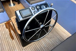 Steering wheel and dashboard of 2010 Isloep Rapida 990 boat on wooden deck.