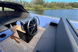Isloep Rapida 990 boat interior with steering wheel, wooden deck, and seating, 2010 model.