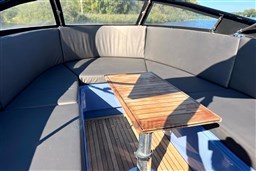 Interior of 2010 Isloep Rapida 990 boat with wooden table and cushioned seating.