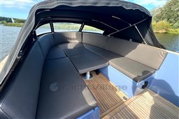 Interior of 2010 Isloep Rapida 990 boat with cushioned seating and canopy.