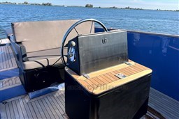 Isloep Rapida 990 boat interior with steering wheel, wooden deck, and seating, 2010 model.