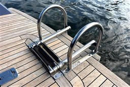 Stainless steel boat ladder on Isloep Rapida 990, 2010 model, with wooden deck and water view.