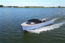 Isloep Rapida 990 boat cruising on a lake, 2010 model, sleek design.