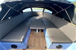 Luxurious interior of 2010 Isloep Rapida 990 boat with cushioned seating and wooden flooring.