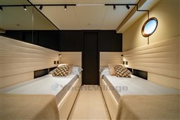 Luxurious twin cabin interior of 2025 VanDutch 75 yacht, featuring modern design and ambient lighting.