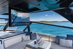 Luxurious VanDutch 75 yacht interior with ocean view, featuring a TV and elegant seating area.