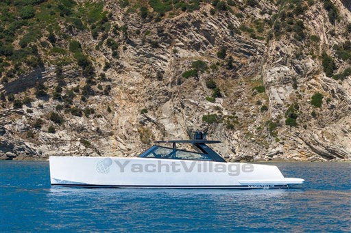 2025 VanDutch 75 yacht cruising near rocky coastline, showcasing sleek design and luxury.