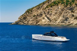 VanDutch 75 yacht cruising near rocky coastline, 2025 model, in clear blue waters.