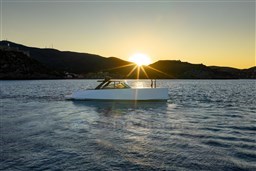 VanDutch 75 yacht cruising at sunset, 2025 model, serene waters, scenic mountain backdrop.