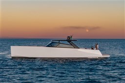 2025 VanDutch 75 yacht cruising at sunset with people on deck.
