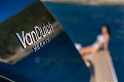 2025 VanDutch 75 yacht with blurred background of a person relaxing on deck.