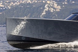 Sleek 2025 VanDutch 48 yacht cruising on water with scenic hillside backdrop.